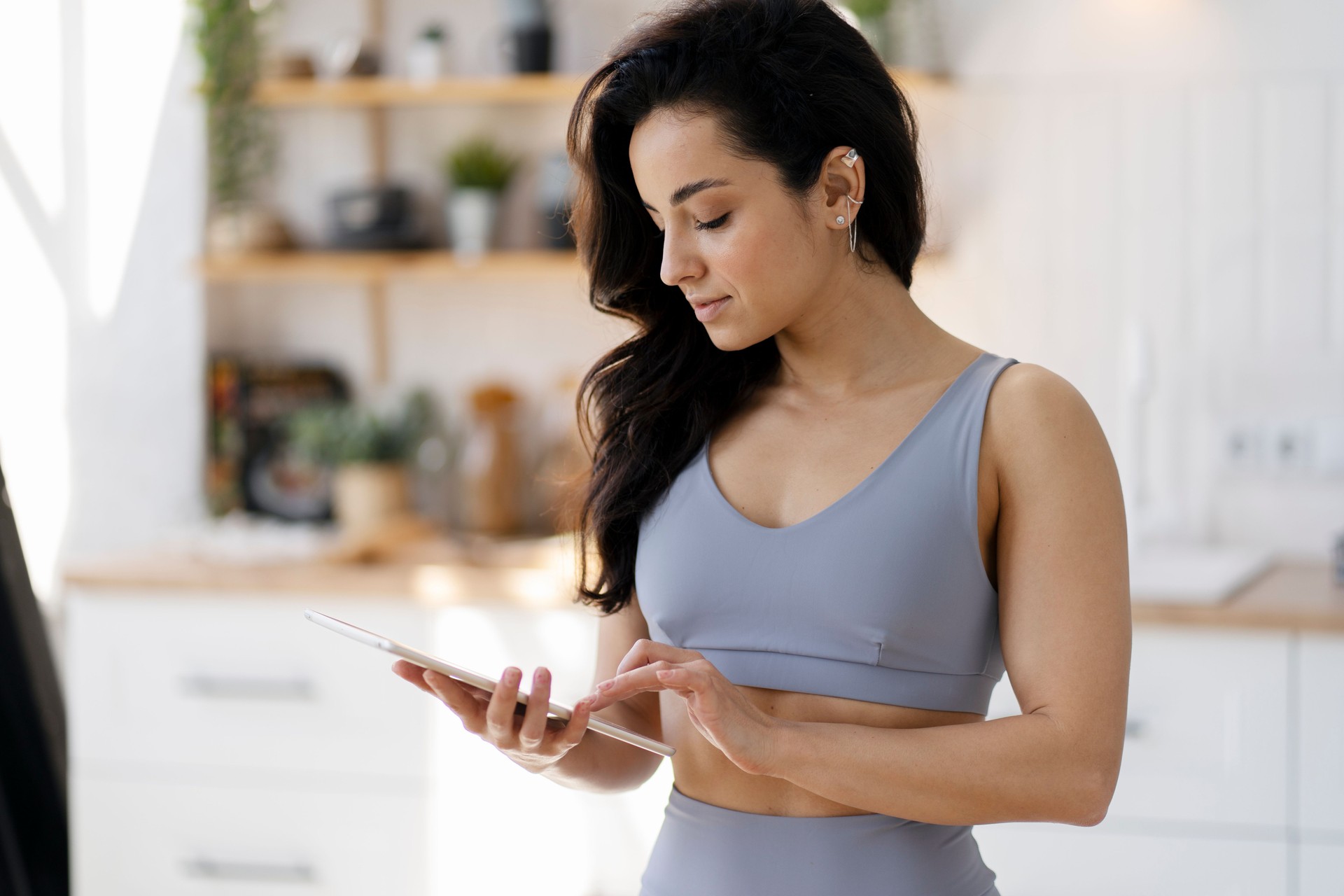 Sportswoman browsing internet on tablet after home workout